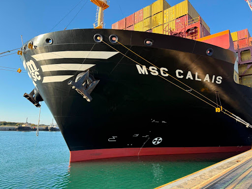 Large container cargo ship docked at port preparing for a merchant navy career journey